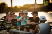 Action picture of women participating in a rowing exercise on a branch of the Chicago River. They are cancer survivors learning how to manage their recovery. Image by Chicago photographer Alex Garcia