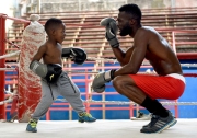 A father and son playfully box during a break in the action at the Havana boxing gym in Cuba.  Chicago photographer Alex Garcia