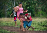 Women and children of Bangkukuk regularly play stickball in an open field in the village while the men of the village are away during the day. Chicago photojournalist Alex Garcia