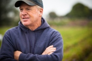 Portrait of farmer in standing in his field looking out over his crops.