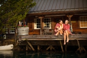 Two young women relax on a dock together aftetr a swim in napa california