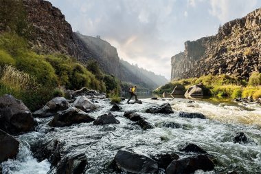 02-Active-Lifestyle-hiker-Jimmy-Chin-crossing-river-rocks-Rod-McLean