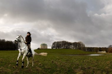 102-Female-riding-white-horse-in-a-field-in-front-of-castle-Rod-McLean