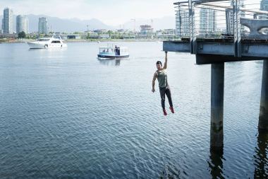 62-Parkour-male-Athlete-hanging-over-water-from-a-bridge-Rod-McLean