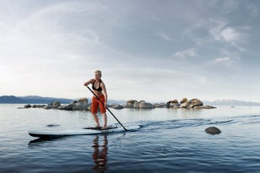 72-Active-Lifestyle-woman-paddle-boarding-on-lake-rocks-Rod-McLean