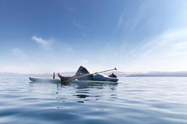 74-Man-laying-on-paddle-board-on-Tahoe-lake-with-mountains-Rod-McLean